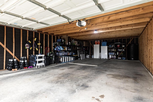 21910 Barton Woods, San Antonio, TX 78259 - garage with water heater, a garage door opener, and freestanding refrigerator