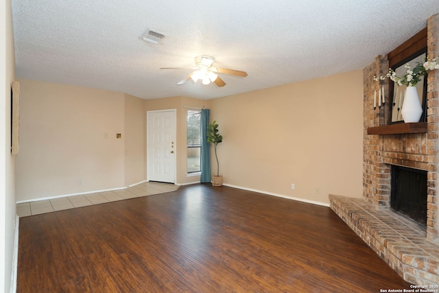 9357 Dover, San Antonio, TX 78250 - unfurnished living room featuring a ceiling fan, wood finished floors, a fireplace, baseboards, and a textured ceiling