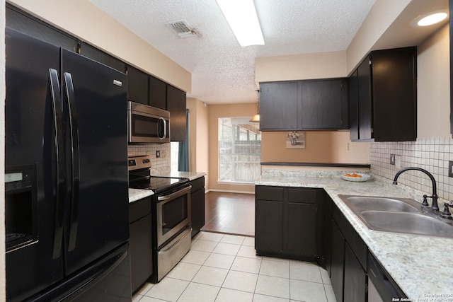 9357 Dover, San Antonio, TX 78250 - kitchen with stainless steel appliances, a sink, light countertops, a textured ceiling, and backsplash