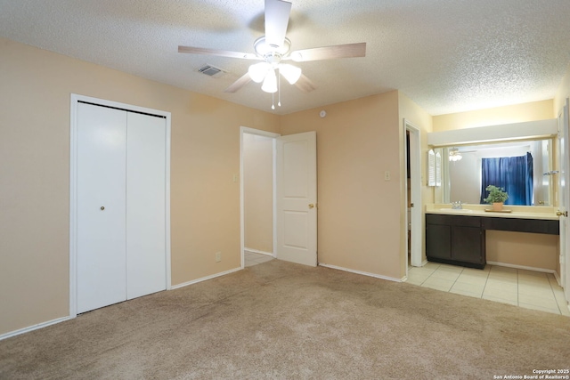 9357 Dover, San Antonio, TX 78250 - unfurnished bedroom featuring a sink, light colored carpet, a textured ceiling, baseboards, and a closet