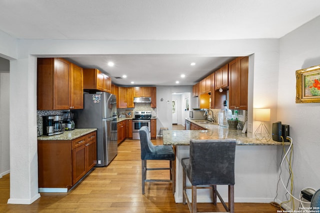 1119 N Pine St, San Antonio, TX 78202 - kitchen with stainless steel appliances, under cabinet range hood, light wood finished floors, a peninsula, and recessed lighting