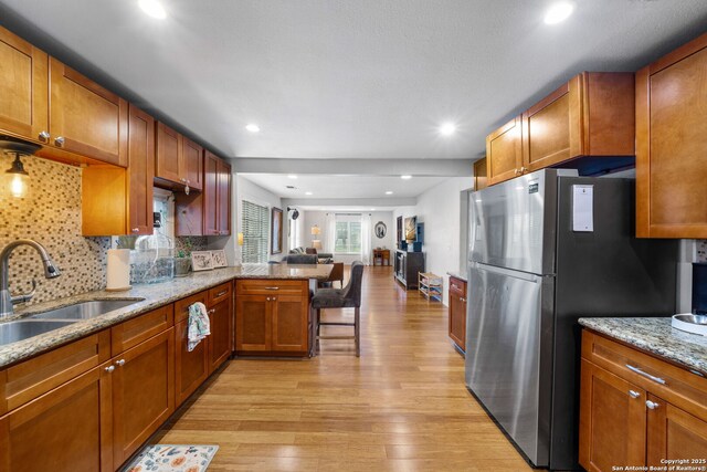 1119 N Pine St, San Antonio, TX 78202 - kitchen with freestanding refrigerator, a sink, light wood-style flooring, a peninsula, and open floor plan