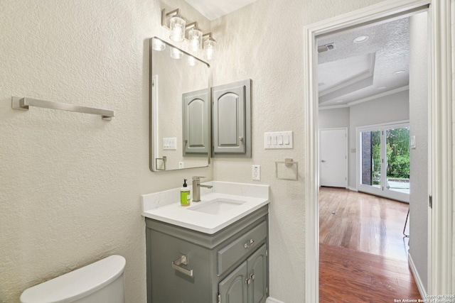 21641 Forest Waters, Garden Ridge, TX 78266 - half bath featuring vanity, wood finished floors, toilet, a textured wall, and crown molding