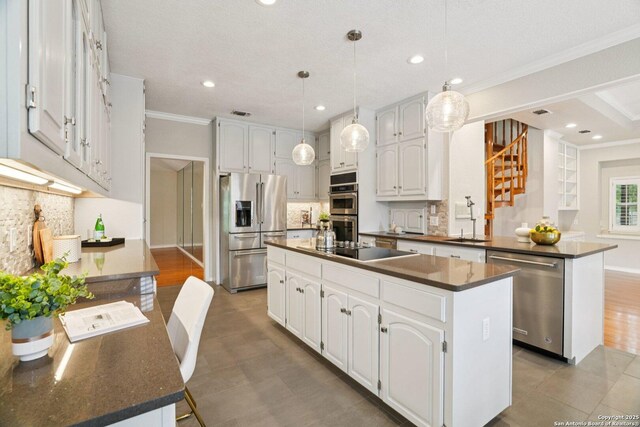 21641 Forest Waters, Garden Ridge, TX 78266 - kitchen with appliances with stainless steel finishes, dark countertops, crown molding, tasteful backsplash, and a center island