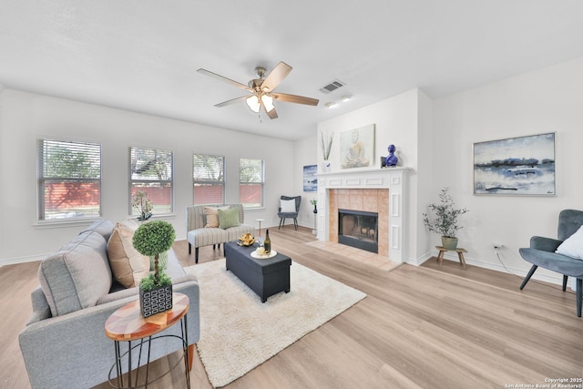 11502 Windwalk, San Antonio, TX 78253 - living room featuring light wood-type flooring, a tile fireplace, ceiling fan, and baseboards