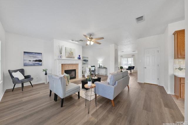 11502 Windwalk, San Antonio, TX 78253 - living room featuring light wood finished floors, a tile fireplace, baseboards, and a ceiling fan