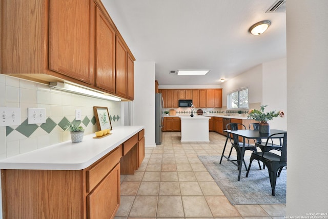 11502 Windwalk, San Antonio, TX 78253 - kitchen with stainless steel appliances, backsplash, brown cabinets, and light countertops
