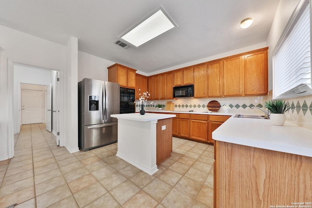 11502 Windwalk, San Antonio, TX 78253 - kitchen with black appliances, a sink, decorative backsplash, light countertops, and a center island
