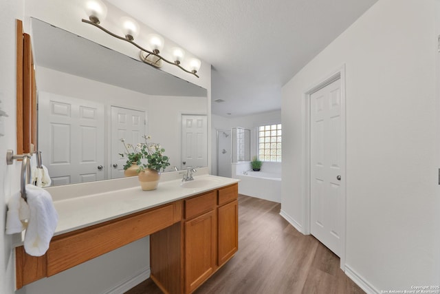 11502 Windwalk, San Antonio, TX 78253 - bathroom with a garden tub, vanity, wood finished floors, a shower with shower door, and a textured ceiling