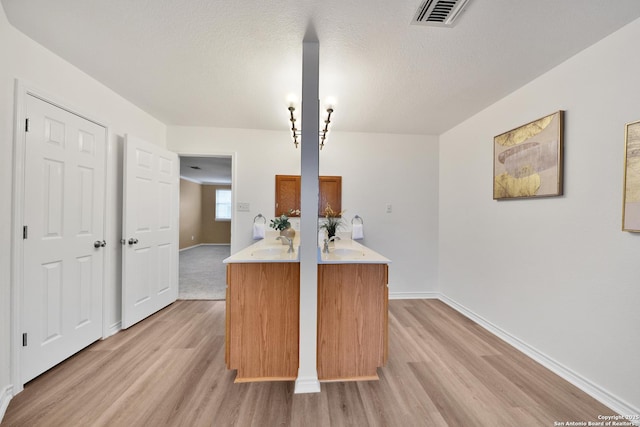 11502 Windwalk, San Antonio, TX 78253 - kitchen with light wood-style floors, light countertops, baseboards, a sink, and a textured ceiling
