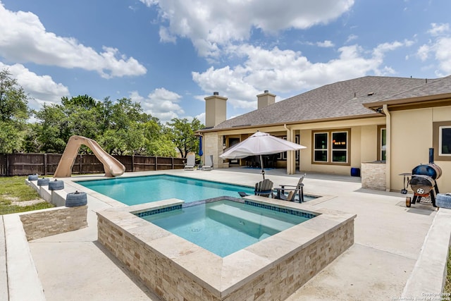 311 Wentworth, Spring Branch, TX 78070 - view of pool with a patio area, a fenced backyard, a water slide, and a pool with connected hot tub