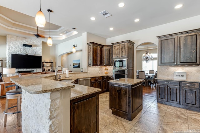 311 Wentworth, Spring Branch, TX 78070 - kitchen with appliances with stainless steel finishes, arched walkways, ornamental molding, a sink, and light stone countertops