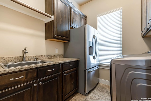 311 Wentworth, Spring Branch, TX 78070 - kitchen with a sink, washer / dryer, stainless steel fridge, dark brown cabinetry, and light countertops