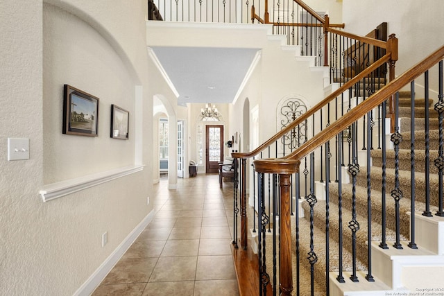 9718 Rosemire Way, San Antonio, TX 78254 - foyer featuring arched walkways, a textured wall, stairs, tile patterned flooring, and baseboards