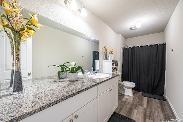8411 Terlingua Cv, Converse, TX 78109 - full bathroom featuring toilet, wood finished floors, vanity, a textured ceiling, and curtained shower