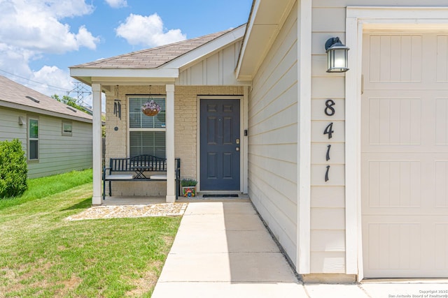 8411 Terlingua Cv, Converse, TX 78109 - doorway to property with covered porch, a yard, roof with shingles, and brick siding