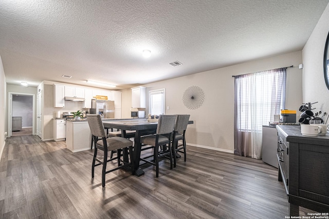 8411 Terlingua Cv, Converse, TX 78109 - dining area featuring dark wood-type flooring, a textured ceiling, and baseboards