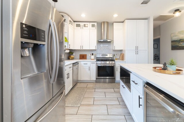 203 Rehmann, San Antonio, TX 78204 - kitchen featuring appliances with stainless steel finishes, wine cooler, island exhaust hood, white cabinetry, and backsplash