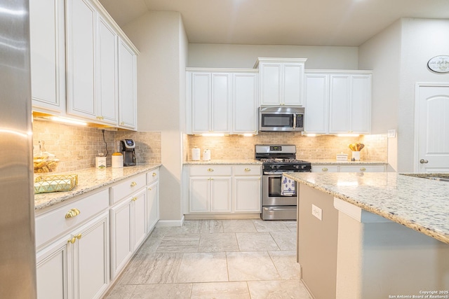 2705 Merlin Ln, Pearland, TX 77581 - kitchen with appliances with stainless steel finishes, white cabinetry, and backsplash
