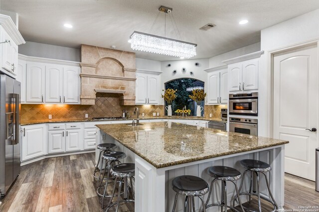 10 Kings Tower, San Antonio, TX 78257 - kitchen featuring appliances with stainless steel finishes, a kitchen bar, dark wood finished floors, white cabinetry, and recessed lighting