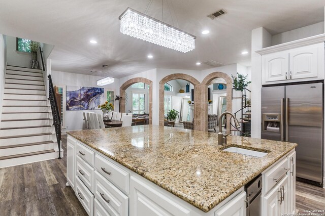10 Kings Tower, San Antonio, TX 78257 - kitchen with stainless steel fridge with ice dispenser, arched walkways, a sink, a kitchen island with sink, and recessed lighting