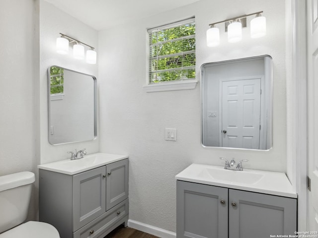 942 San Angelo, San Antonio, TX 78201 - bathroom with vanity, wood finished floors, toilet, and baseboards