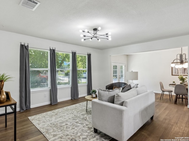 942 San Angelo, San Antonio, TX 78201 - living room with a chandelier, dark wood-style flooring, french doors, a textured ceiling, and baseboards