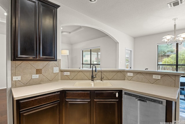 9815 Leubeck Rnch, Helotes, TX 78023 - kitchen featuring dishwasher, a sink, arched walkways, light countertops, and a peninsula