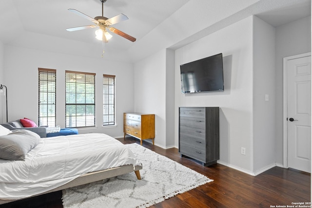 9815 Leubeck Rnch, Helotes, TX 78023 - bedroom with dark wood-style flooring, a raised ceiling, baseboards, and a ceiling fan