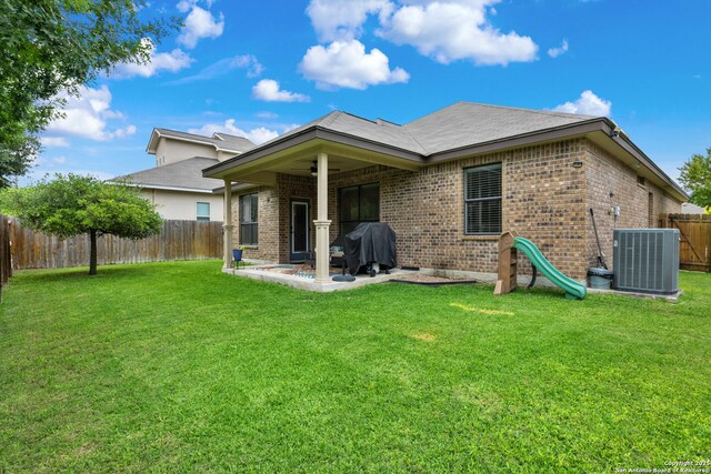 9815 Leubeck Rnch, Helotes, TX 78023 - rear view of property with central AC, brick siding, and a patio