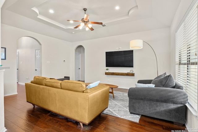 9815 Leubeck Rnch, Helotes, TX 78023 - living area featuring arched walkways, a raised ceiling, a ceiling fan, dark wood-type flooring, and recessed lighting