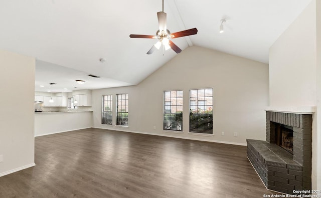 12406 Autumn Vis, San Antonio, TX 78249 - unfurnished living room with ceiling fan, a fireplace, dark wood finished floors, vaulted ceiling, and baseboards