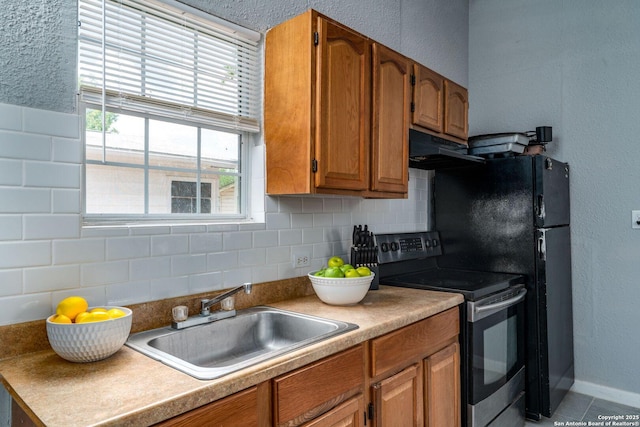 222 Laurelwood, San Antonio, TX 78213 - kitchen with stainless steel range with electric cooktop, under cabinet range hood, a sink, decorative backsplash, and brown cabinets