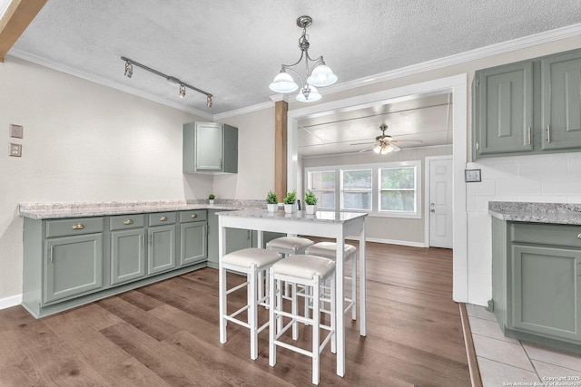 239 Banbridge, San Antonio, TX 78223 - kitchen featuring crown molding, wood finished floors, a textured ceiling, a ceiling fan, and pendant lighting
