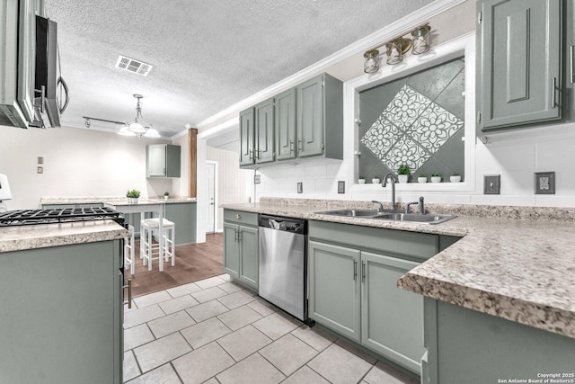 239 Banbridge, San Antonio, TX 78223 - kitchen with stainless steel appliances, a sink, a textured ceiling, crown molding, and light countertops