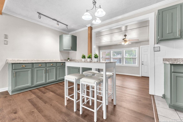 239 Banbridge, San Antonio, TX 78223 - kitchen featuring dark wood-type flooring, green cabinets, ornamental molding, light countertops, and ceiling fan
