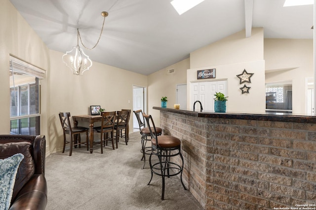 585 Oak Bend Dr, Bandera, TX 78003 - kitchen featuring carpet flooring, plenty of natural light, beam ceiling, a chandelier, and a breakfast bar area