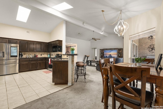 585 Oak Bend Dr, Bandera, TX 78003 - kitchen featuring stainless steel fridge with ice dispenser, stove, black microwave, dark brown cabinetry, and a chandelier