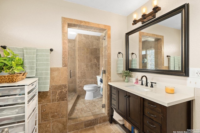585 Oak Bend Dr, Bandera, TX 78003 - full bath with vanity, toilet, a shower stall, and tile walls