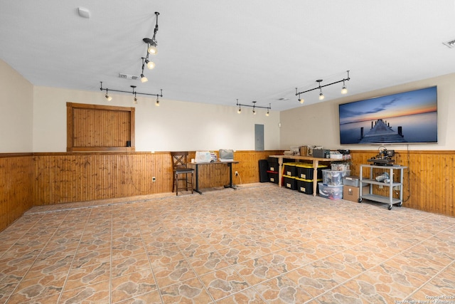 585 Oak Bend Dr, Bandera, TX 78003 - living area with wood walls, wainscoting, stone finish floors, track lighting, and electric panel