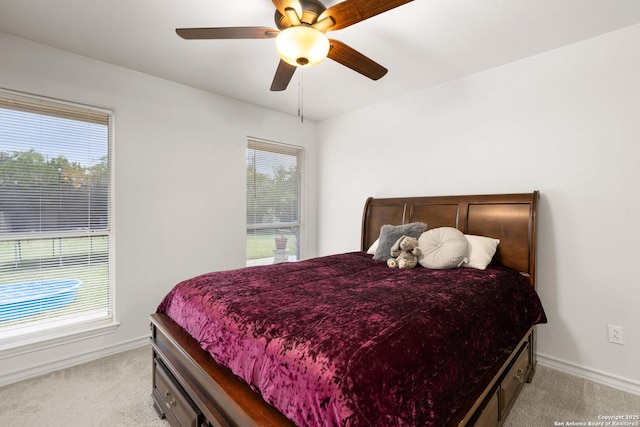 585 Oak Bend Dr, Bandera, TX 78003 - bedroom with light carpet, multiple windows, baseboards, and ceiling fan