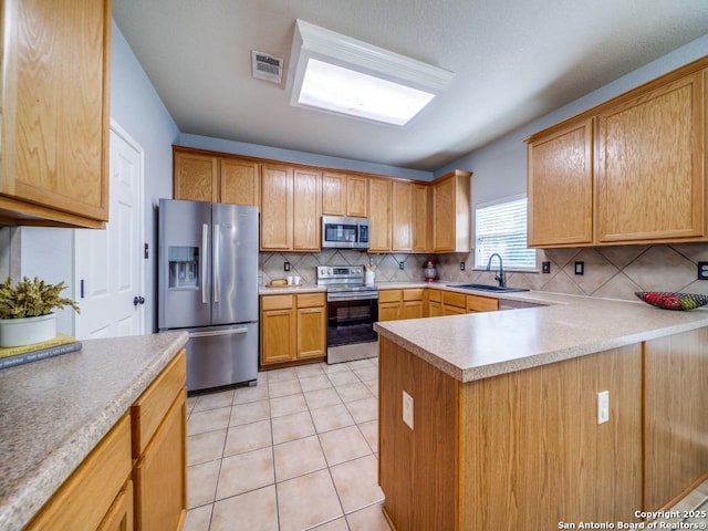 520 Foxford Run Dr, Schertz, TX 78108 - kitchen with stainless steel appliances, a sink, tasteful backsplash, light countertops, and a peninsula
