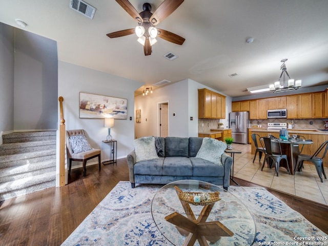 520 Foxford Run Dr, Schertz, TX 78108 - living area featuring a ceiling fan, a chandelier, light wood-style floors, and stairway