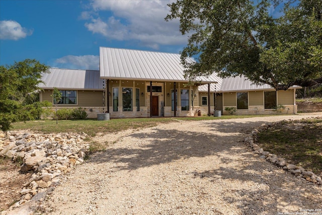 122 Twisting Oaks Ct, Pipe Creek, TX 78063 - view of front of property featuring dirt driveway, metal roof, stone siding, and a porch