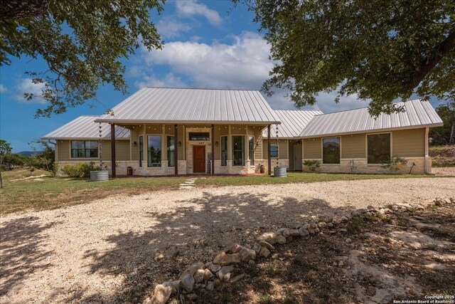 122 Twisting Oaks Ct, Pipe Creek, TX 78063 - view of front of home with stone siding, covered porch, and metal roof