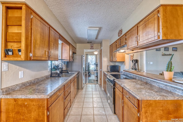 105 S Bluebonnet, Uvalde, TX 78801 - kitchen featuring range with electric stovetop, brown cabinets, a sink, under cabinet range hood, and a textured ceiling