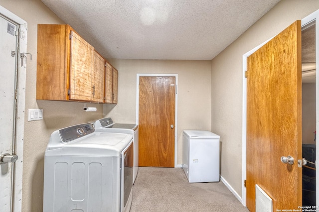 105 S Bluebonnet, Uvalde, TX 78801 - washroom featuring washer and dryer, light carpet, cabinet space, a textured ceiling, and baseboards
