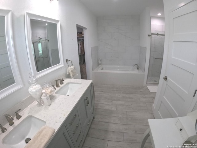 524 Flaman, Canyon Lake, TX 78133 - bathroom featuring a garden tub, a shower stall, double vanity, wood finished floors, and recessed lighting