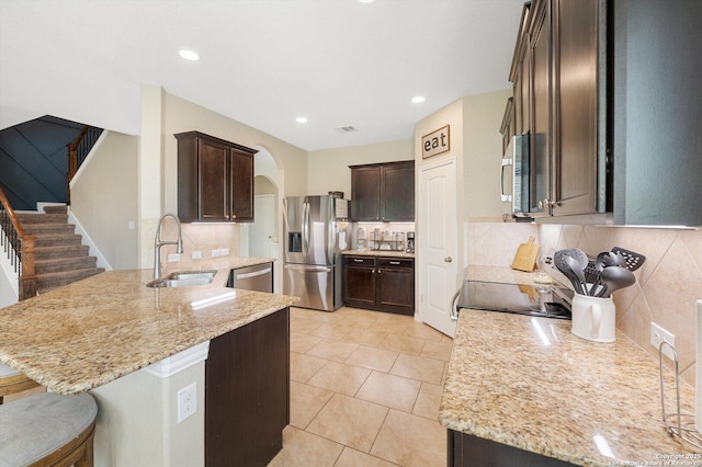 1989 Kalli Jo, New Braunfels, TX 78130 - kitchen with appliances with stainless steel finishes, a sink, a peninsula, dark brown cabinets, and tasteful backsplash