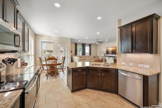 1989 Kalli Jo, New Braunfels, TX 78130 - kitchen featuring stainless steel appliances, a sink, a peninsula, backsplash, and dark brown cabinetry